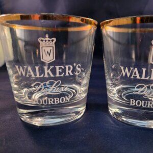 Clear glass tumblers with gold rim and etched Walker's Deluxe Bourbon branding.